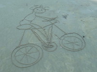 2015.09.13 Friendly bicycling cartoon on the sand of a Thai beach.
