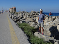 2019.06.06 On stone breakwaters of the outer side of the Mandraki Bay, with decorative windmills in the background.