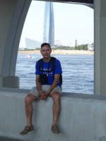 2021.07.11 Sitting on a border curb of the Neva Bay embankment against the background of the Lakhta Center and the “football” studio of the “Match TV” channel.